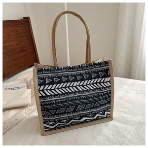 Detail of bohemian jute tote bag featuring geometric tribal patterns and rope handles