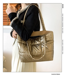 Gros plan d'un sac cabas doré matelassé avec texture métallisée et surpiqûres