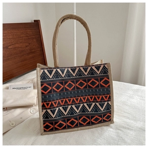 Detail of woven round handles and bohemian geometric pattern on a jute tote bag