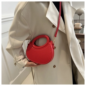 Detail of red crescent bag with pleated PU leather texture and ring handle