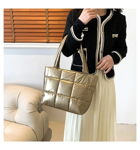 Gros plan d'un sac à main matelassé or champagne avec une texture quadrillée tendance