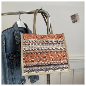Close-up of bohemian linen tote bag with geometric patterns hanging next to denim jacket