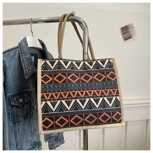 Detail of bohemian woven tote bag with orange and black geometric ethnic patterns