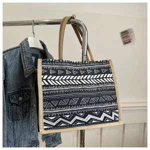 Detail of bohemian burlap tote bag with black and white geometric print on a hanger