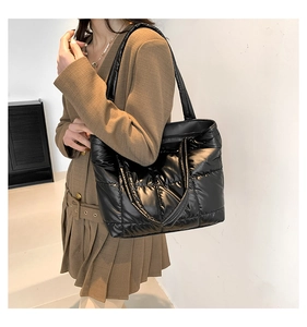 Close-up of black quilted puffer tote bag with high-gloss finish and puffy shoulder straps