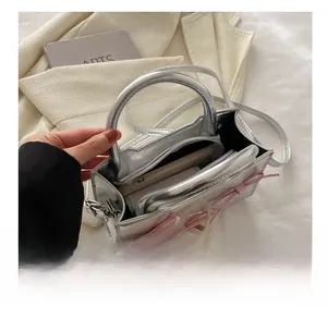 Detail view of the silver PU handbag interior with functional main compartment and zip pocket