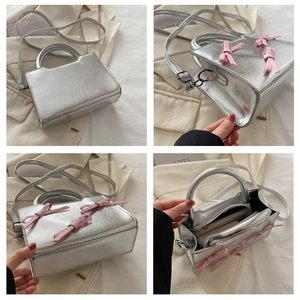 Détails du petit sac carré argenté avec nœuds roses et bandoulière réglable