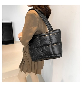 Vue latérale d'un mannequin portant un sac cabas matelassé noir en nylon brillant