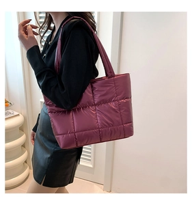 Sac fourre-tout matelassé fuchsia avec motif à carreaux porté par un mannequin en intérieur