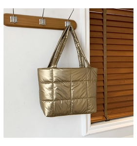 Détail du matelassage doré métallisé et de la texture rembourrée du sac fourre-tout