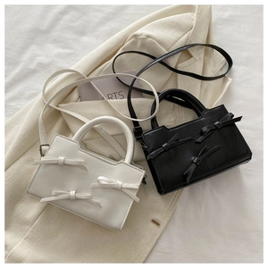 Détails des mini sacs bandoulière avec nœuds papillon en noir et blanc cuir