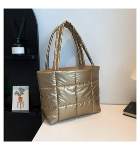 Vue détaillée du sac cabas doré matelassé avec motif à carreaux et texture métal