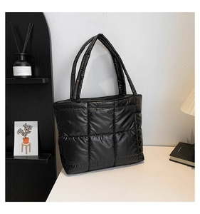 Détail du sac cabas en coton matelassé noir avec surpiqûres carrées et texture moelleuse