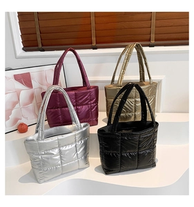 Close-up of quilted tote bags in metallic burgundy, gold, silver, and black finishes
