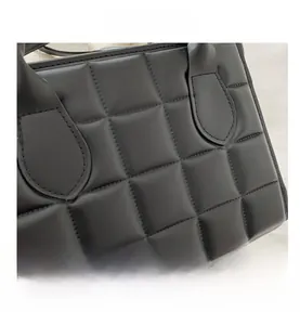Close-up of classic black quilted leather tote showing detailed stitching and texture
