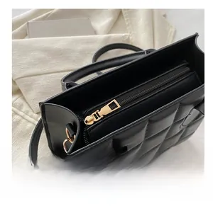 Close-up of black quilted bag showing smooth golden metal zipper and polished hardware detail