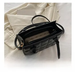 Interior view of black quilted handbag showing large capacity and zipper pocket