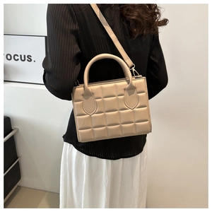 Detail of minimalist beige quilted crossbody bag with stylish square stitching pattern