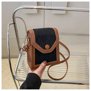 Détail du petit sac matelassé bicolore avec bordure en cuir marron et boucle magnétique