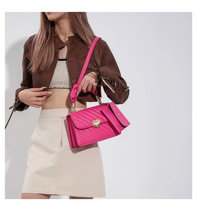 Detail of rose pink quilted crossbody bag with heart buckle and hanging pouch
