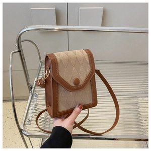 Détail du matériau tissé matelassé beige et de la bordure en cuir marron du sac