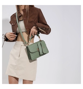 Detail of avocado green crossbody bag featuring quilted texture and stylish ruffled handle
