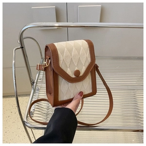 Mini sac bandoulière matelassé avec détails en cuir marron sur étagère minimaliste