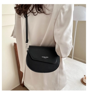 Détail du sac selle noir semi-circulaire avec texte Fashion Trend blanc sur cuir mat lisse