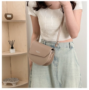 Détail d'un sac besace beige avec texte Fashion Trend dans un décor minimaliste chic