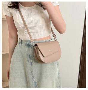 Détail du sac selle minimaliste crème avec bandoulière réglable et cuir mat lisse