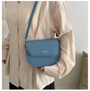 Vue latérale d'un sac besace bleu clair en cuir avec texte 'Fashion Trend' porté par un mannequin