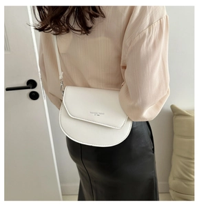Vue arrière du mannequin portant un sac selle blanc demi-rond avec bandoulière réglable