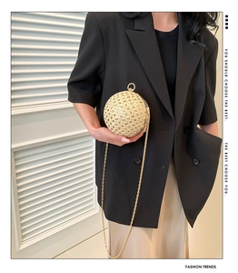 Detail of a luxury gold sphere evening bag with hollow metalwork and sparkling rhinestones