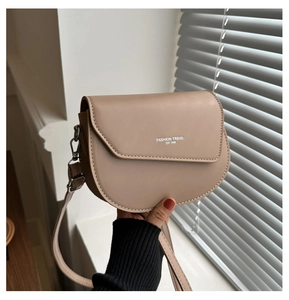 Gros plan détaillé du sac besace beige en cuir avec texte imprimé tendance