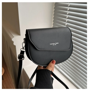 Gros plan du sac de selle noir mat avec impression Fashion Trend et boucles argentées