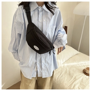 Close-up of black nylon fanny pack with adjustable strap and white brand label