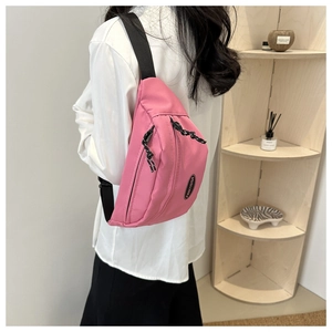 Pink nylon belt bag with adjustable strap shown from a back-view perspective on a model
