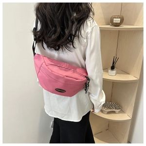 Dettaglio del borsello monospalla in nylon rosa con tracolla regolabile e logo sul retro