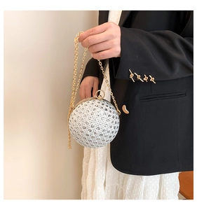Macro view of spherical rhinestone evening clutch with gold chain strap and ring handle