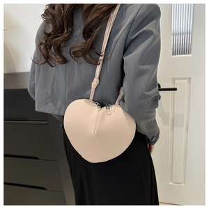 Sac à bandoulière minimaliste en forme de cœur crème avec double fermeture éclair sur modèle