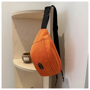 Dettaglio del marsupio in nylon arancione con doppia zip e logo in gomma FANYISSA