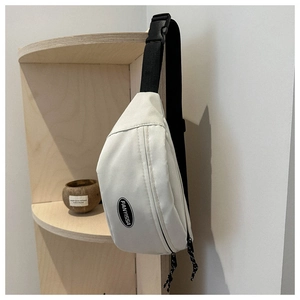 Dettaglio del marsupio in tessuto oxford beige con tracolla nera e logo del marchio