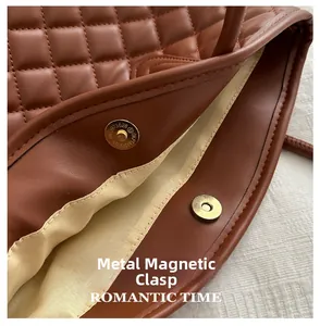 Detail of the magnetic metal closure on dark brown quilted diamond-pattern bucket bag