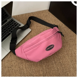Dettaglio del borsello rosa in oxford con logo rotondo e tracolla in nylon regolabile