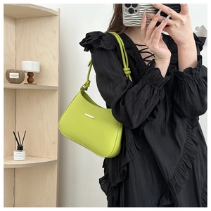 Detail of lime green crescent shoulder bag with gold buckle and knotted strap