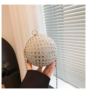 Detail of a sparkling spherical evening clutch with silver rhinestones and gold chain