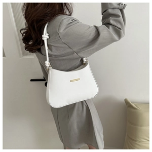 Close-up of a white PU leather shoulder bag featuring unique knotted strap details