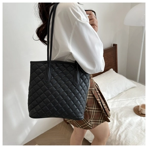 Quilted black tote bag with rhombus pattern shown on model for daily commuting style