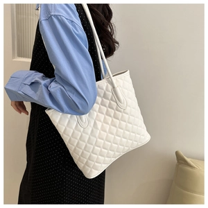 Minimalist white quilted tote bag with rhombus pattern on model for daily commuting