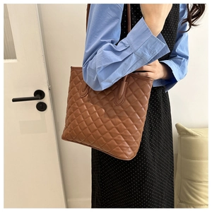 Detailed close-up of brown quilted PU leather tote bag with classic diamond lattice pattern